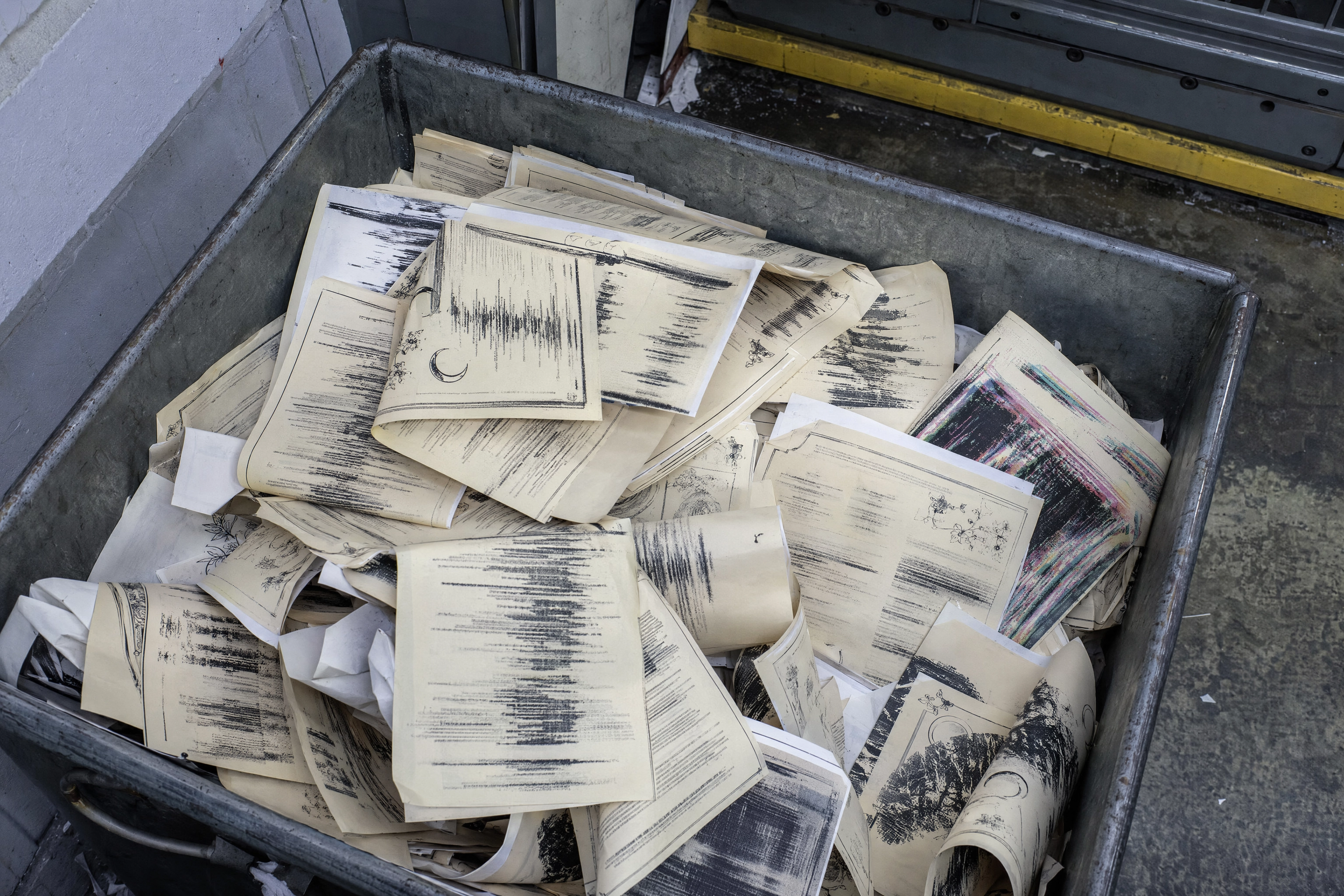Creased misprinted menu sheets in a print shop reject bin with smeared unreadable type from a text-to-image generator