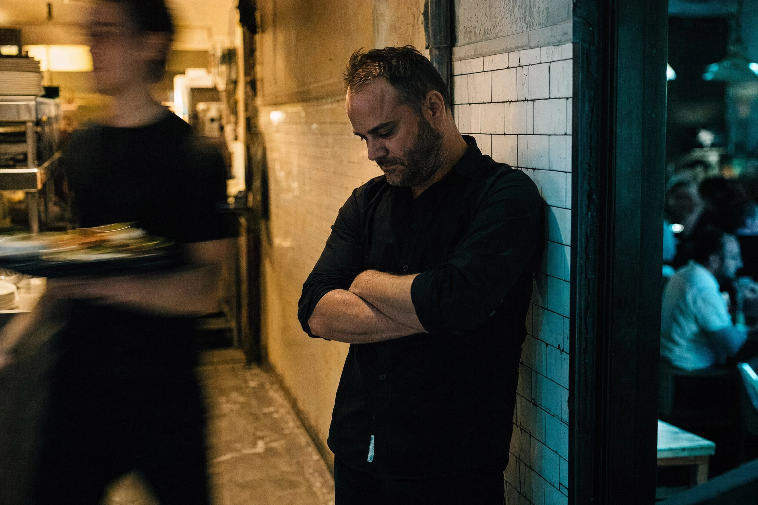Restaurant manager pausing in the service corridor late at night, the shift knowledge no AI review reply tool has