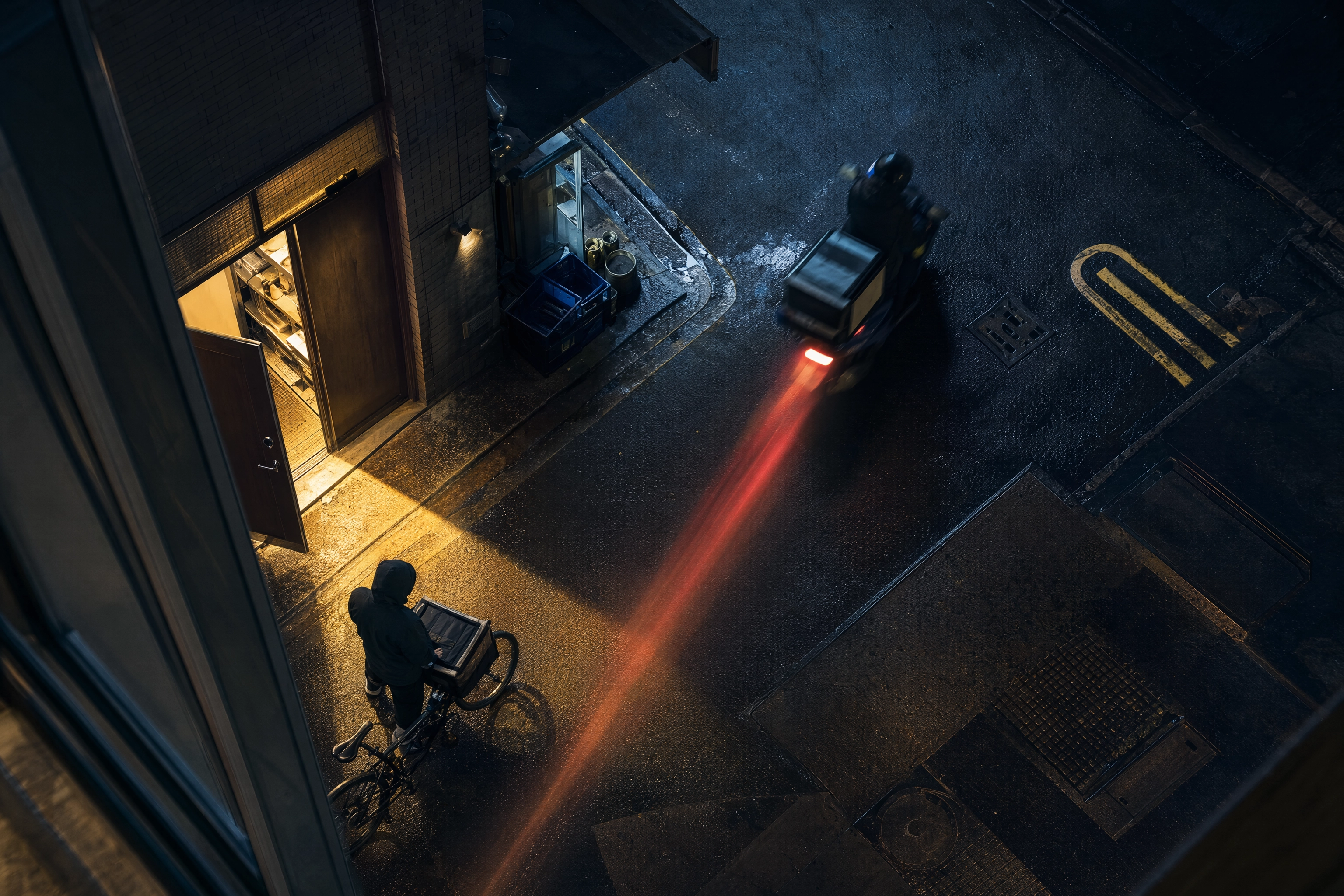 Overhead night view of a delivery scooter leaving a restaurant service door with a red light trail, delivery app promo orders