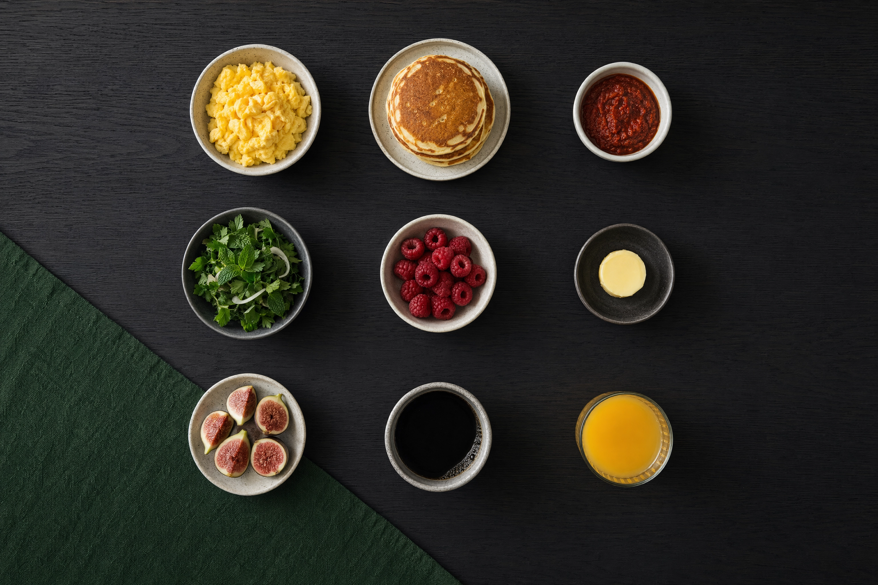 Overhead grid of nine small brunch plates evenly spaced on a dark oak table for shareable social content