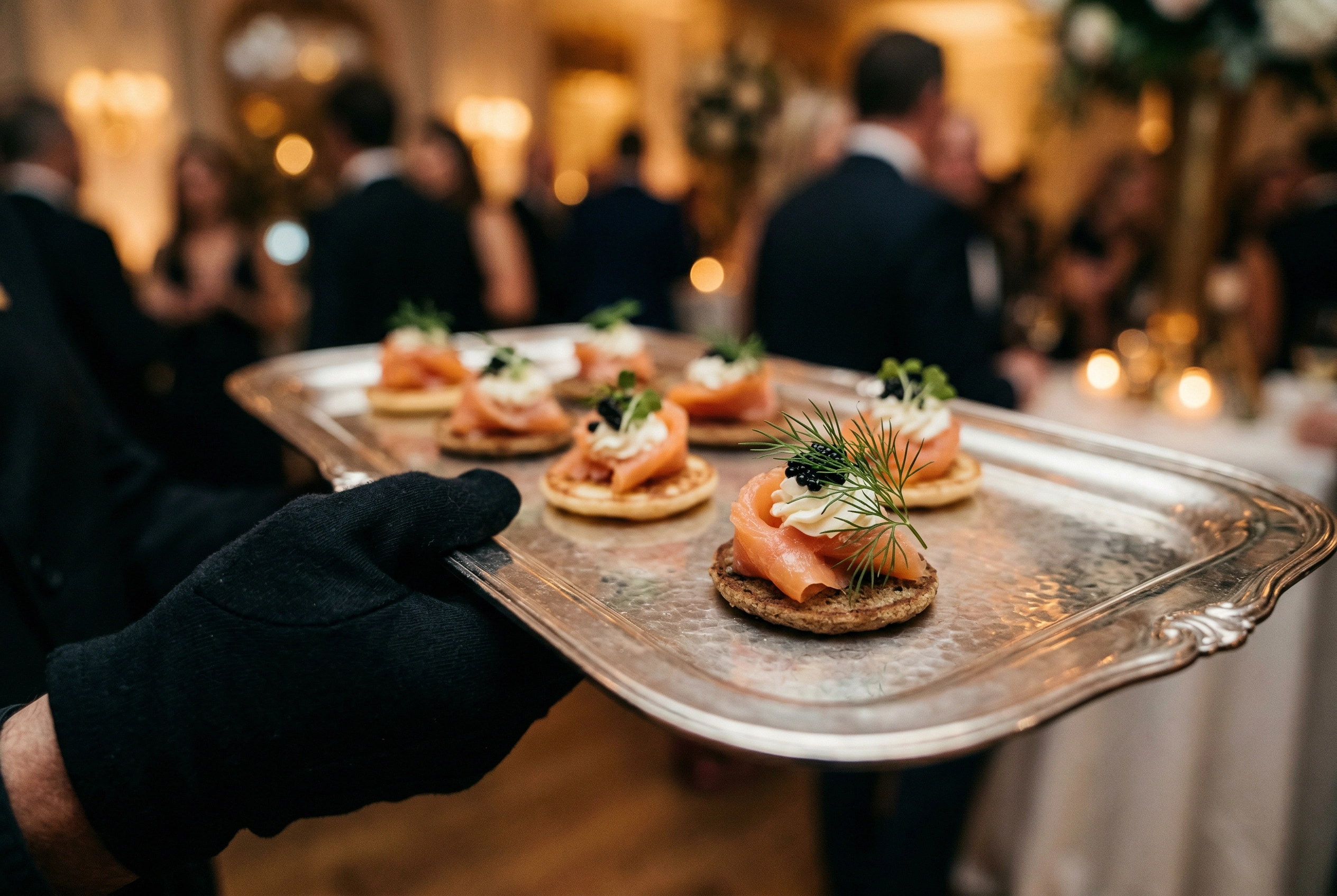 لقطة مقرّبة لمقبلات مقدمة على صينية فضية مع كاناپيه سلمون مدخن في حفل كوكتيل ضيافة