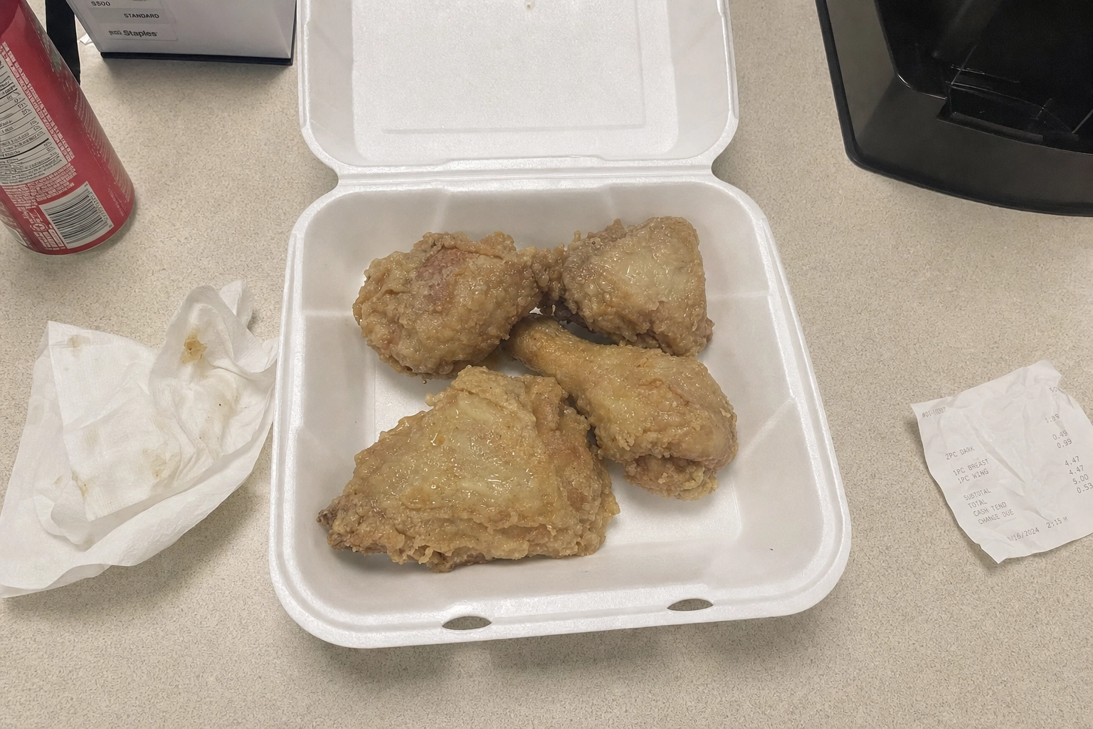 Pale greasy fried chicken in a foam takeout box under harsh flat fluorescent light — a bad chicken photo before editing