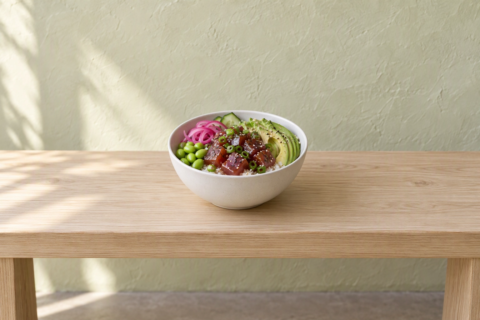 Poke bowl centered on a wide ash bench with empty space on each side, composed to survive the DoorDash square crop