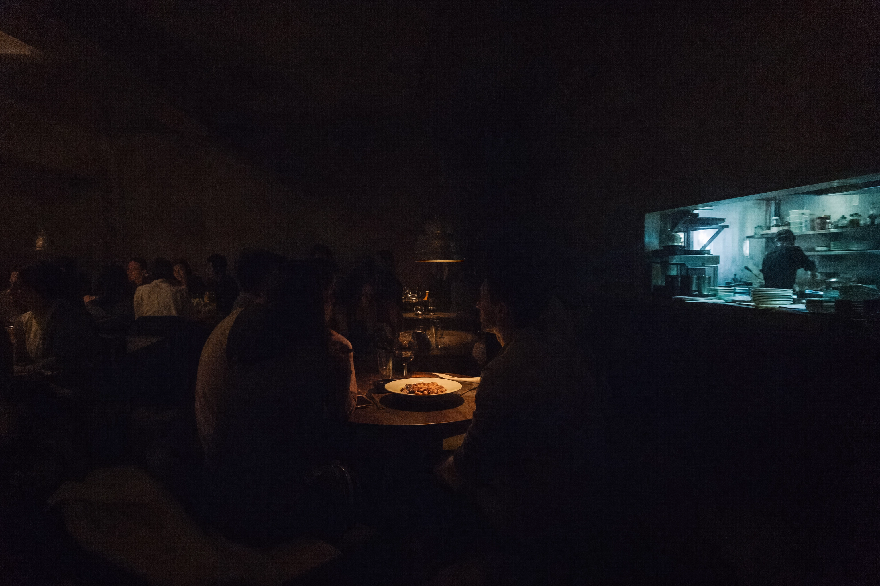 Dim restaurant dining room at dinner service showing the low light levels that challenge food photography cameras