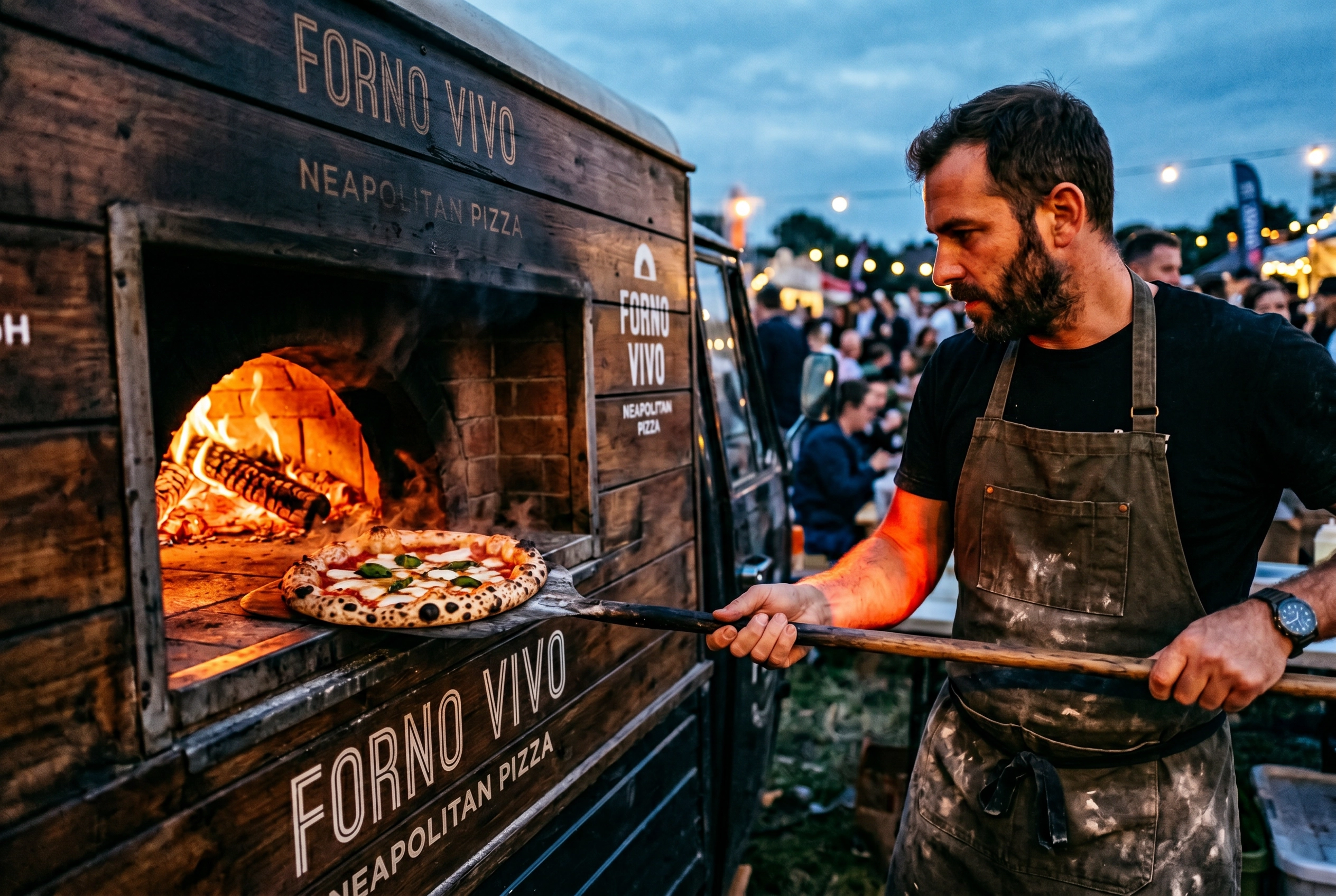 Wood-fired pizza truck at dusk with glowing oven flames and pizzaiolo pulling a leopard-charred Neapolitan pizza out on a wooden peel