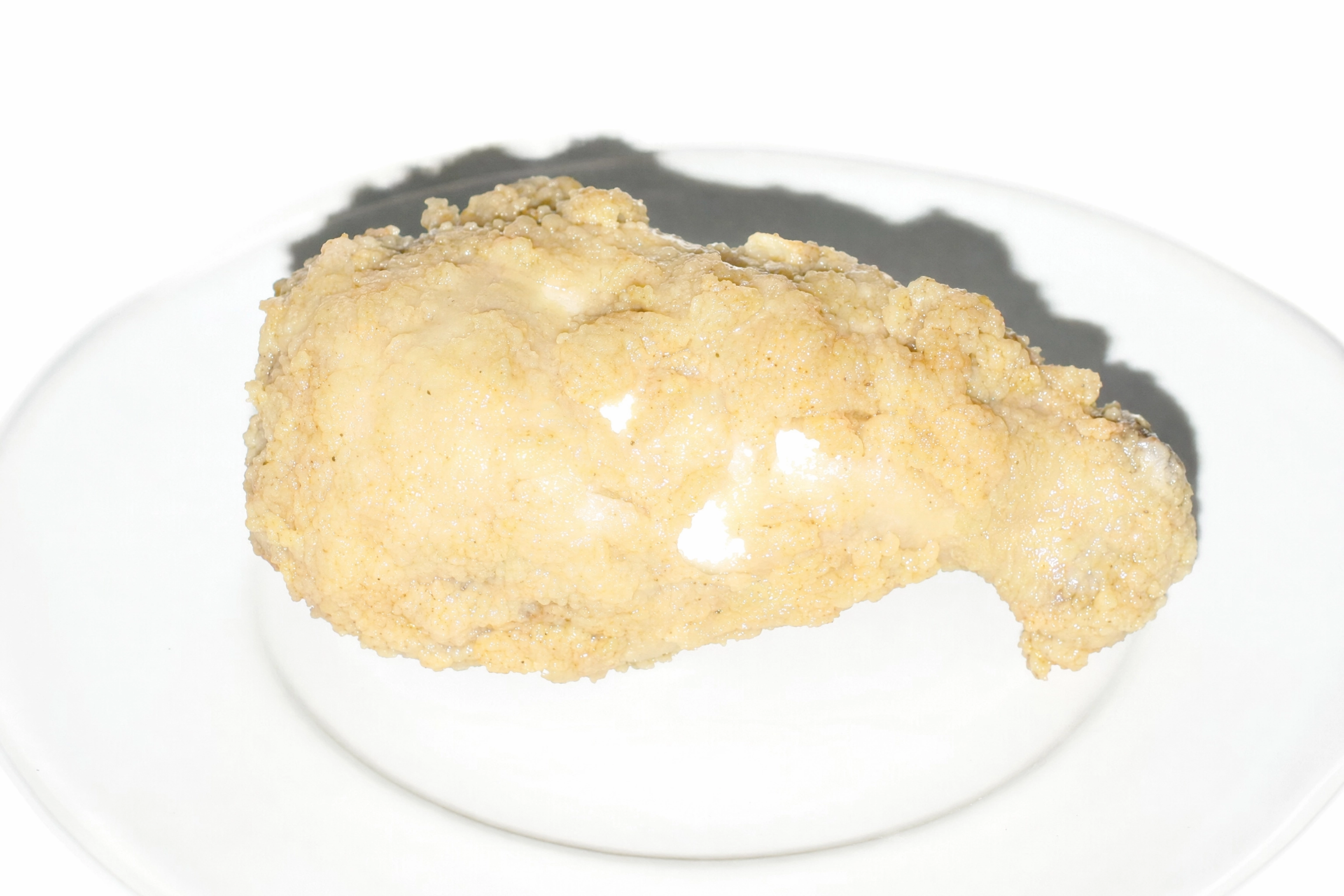 Fried chicken lit flat by harsh direct on-camera flash, looking plasticky and washed out with blown highlights