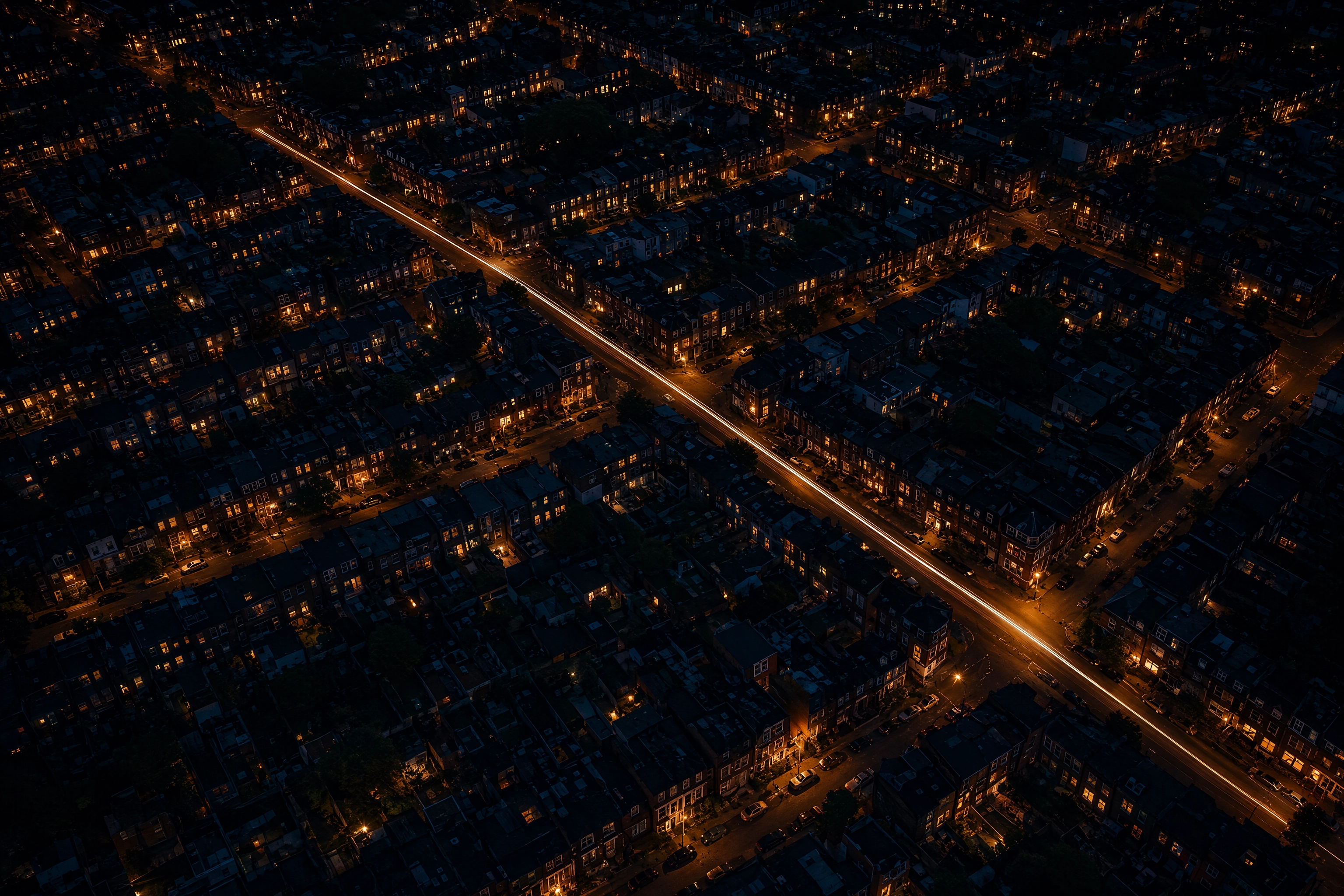 Aerial night view of a lit residential neighbourhood with one courier scooter light, showing a ghost kitchen delivery radius