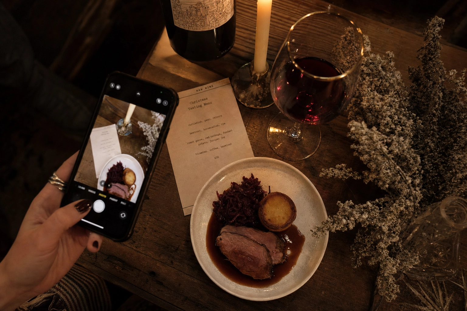 Smartphone photographing a Christmas tasting menu plate in a London restaurant showing seasonal menu refresh use case