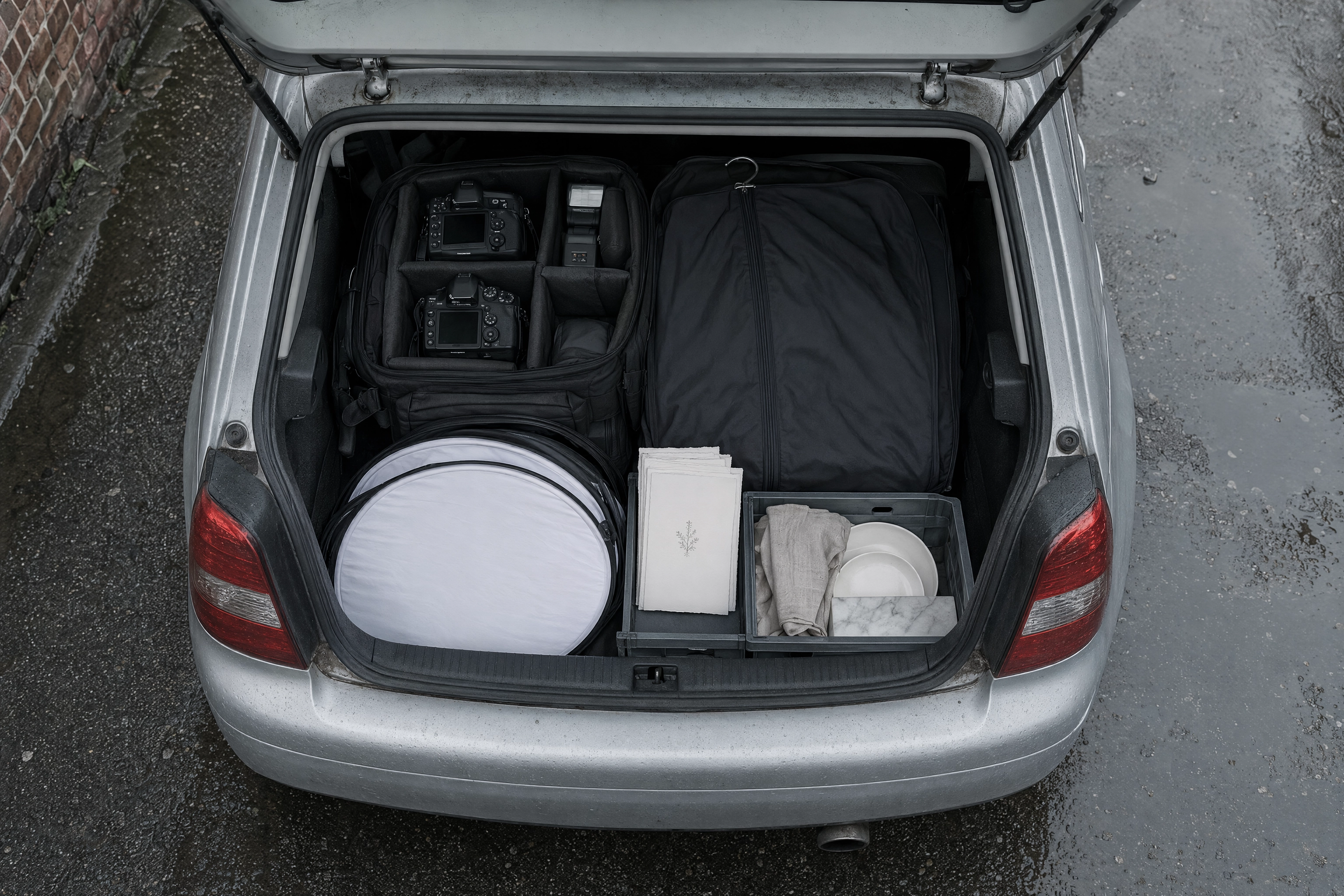 Overhead view of a photographer's car boot in Manchester holding wedding kit alongside a small food prop crate