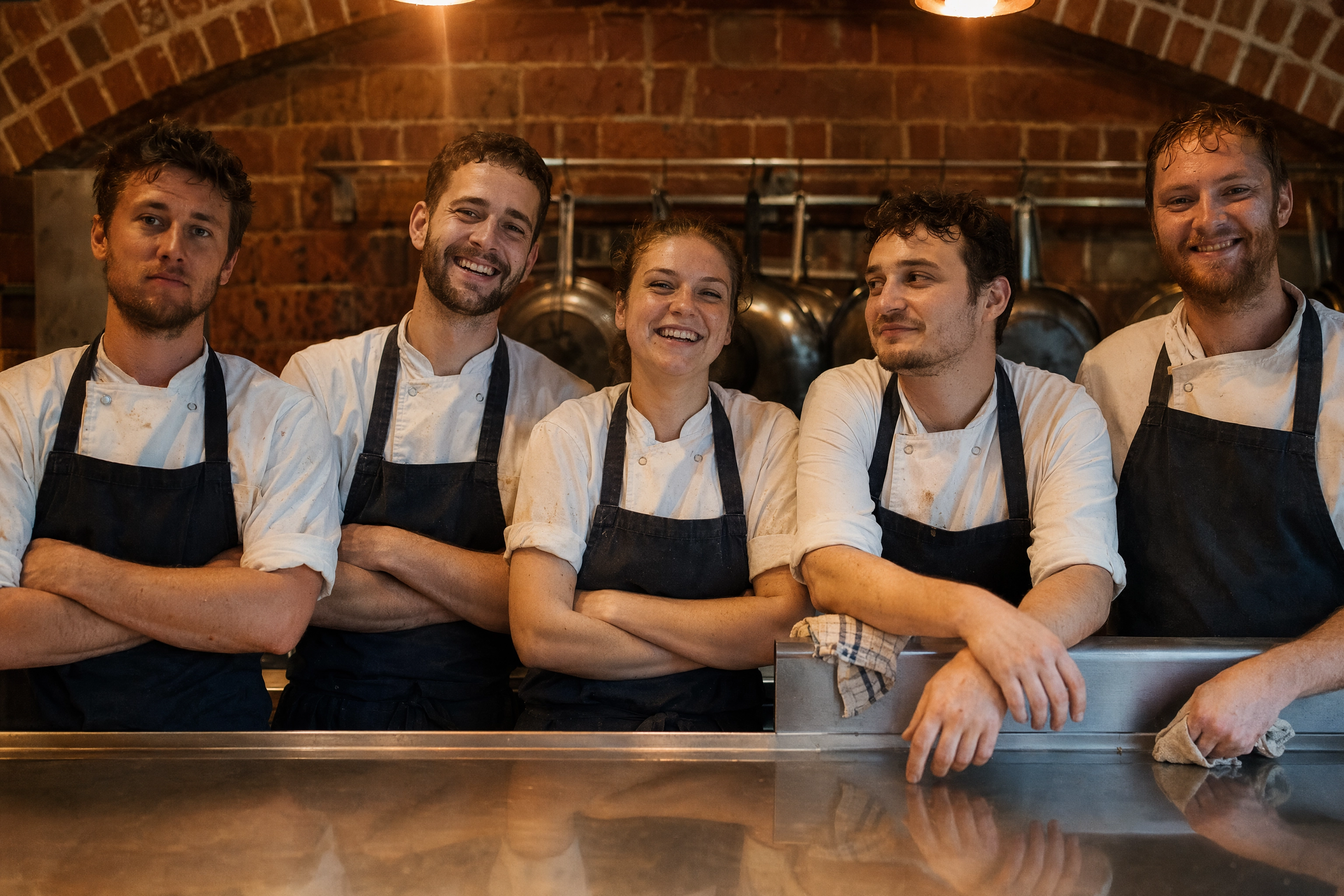 Kitchen brigade team portrait at the pass in a Manchester restaurant, the people work AI photography cannot replace