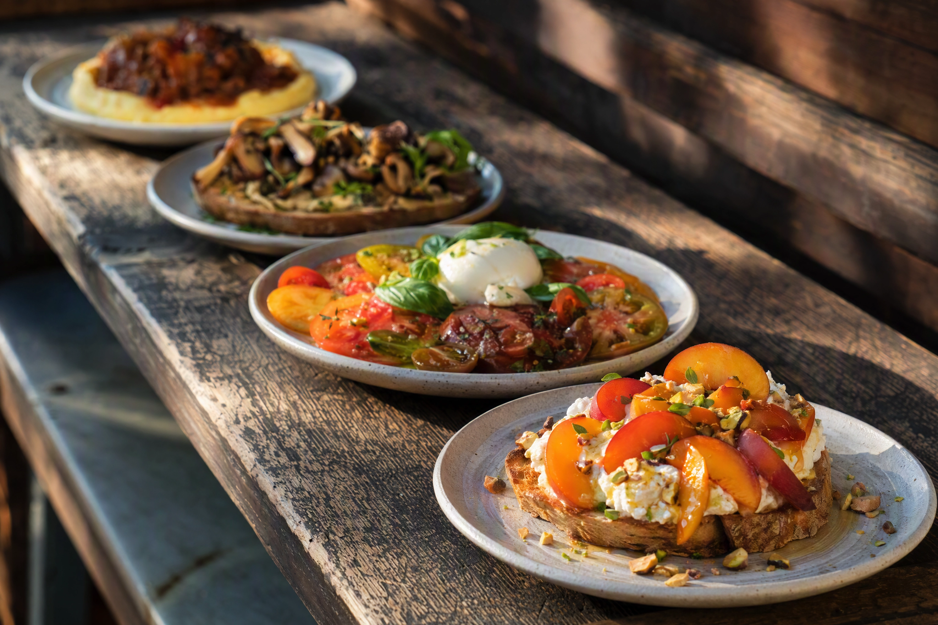 Four seasonal brunch dishes in a row showing the menu rotation that drives repeat food photography costs