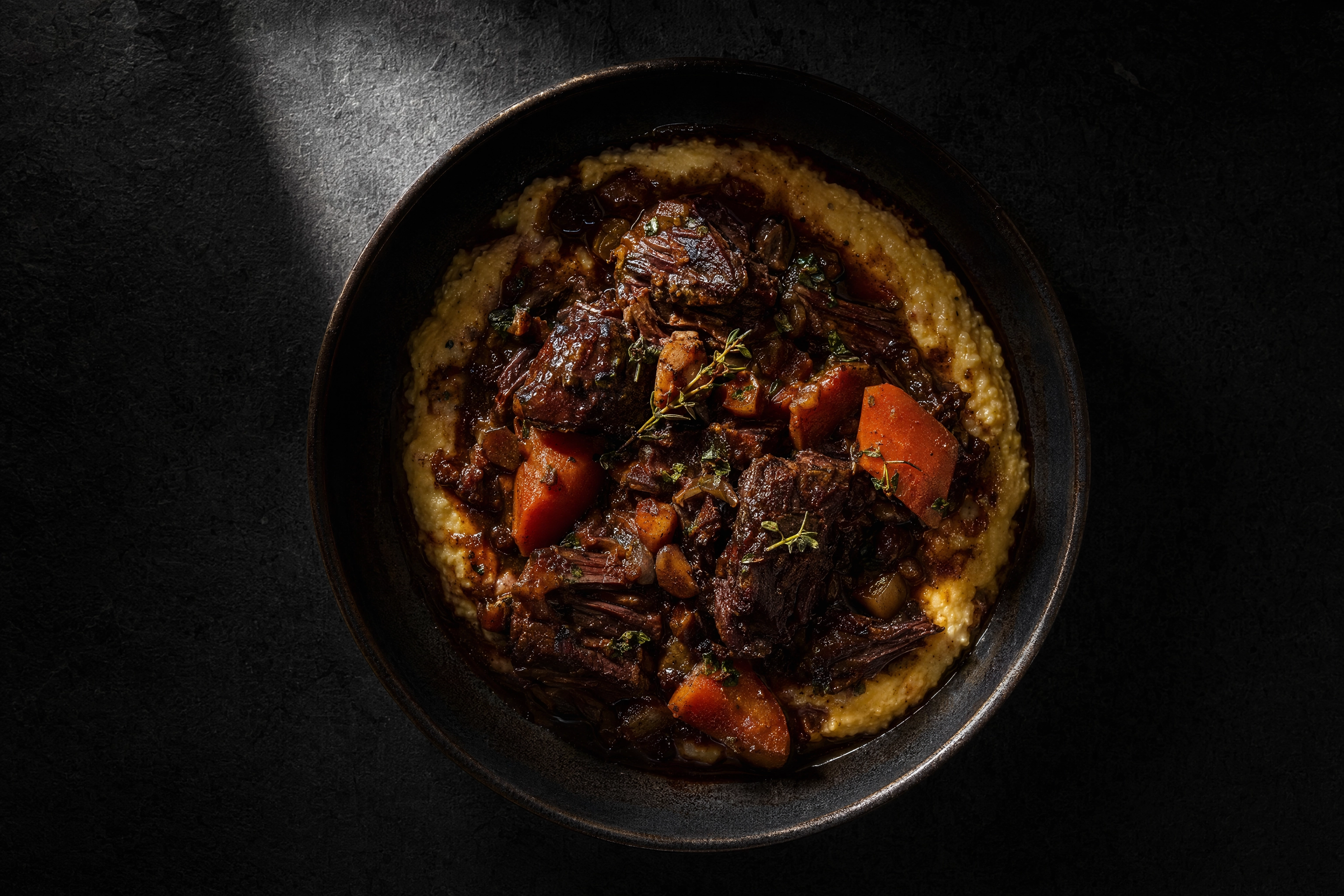 Overhead moody shot of a winter braise, the seasonal dish that replaces a summer menu photo