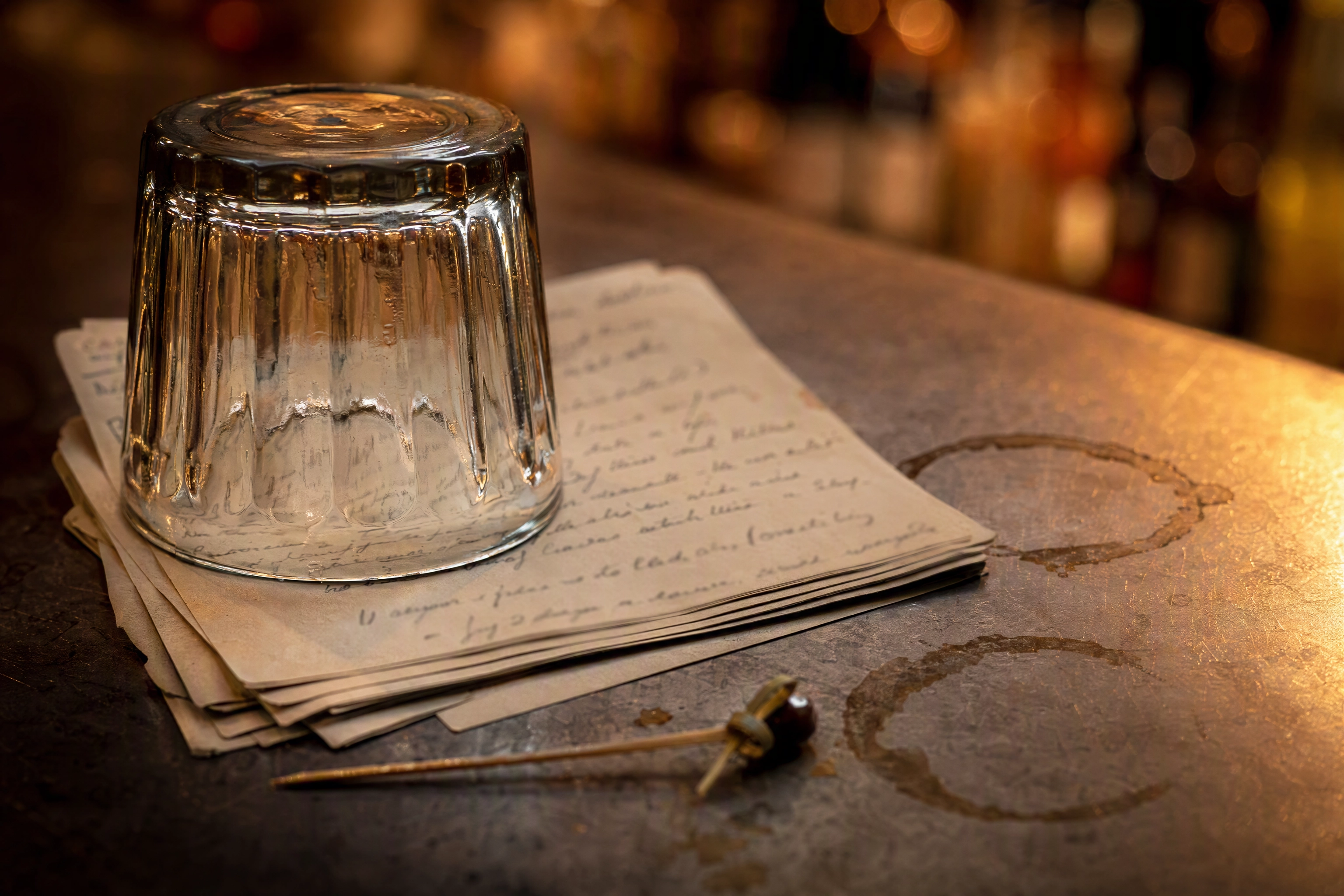 Stack of handwritten guest comment cards under a tumbler on a bar top, social proof for restaurant content