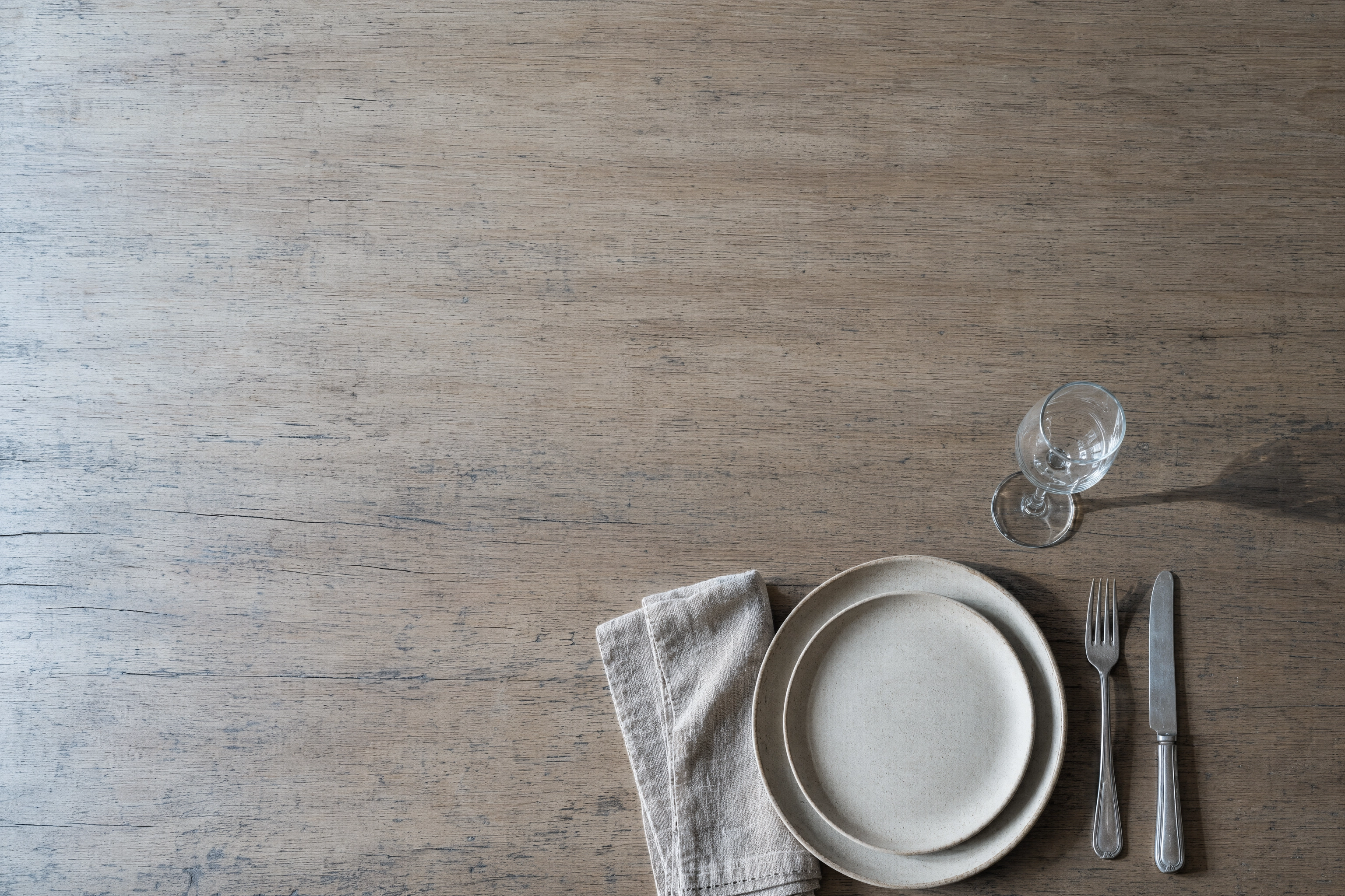 Overhead empty table setting on oak with large negative space, the background frames a restaurant photoshoot needs