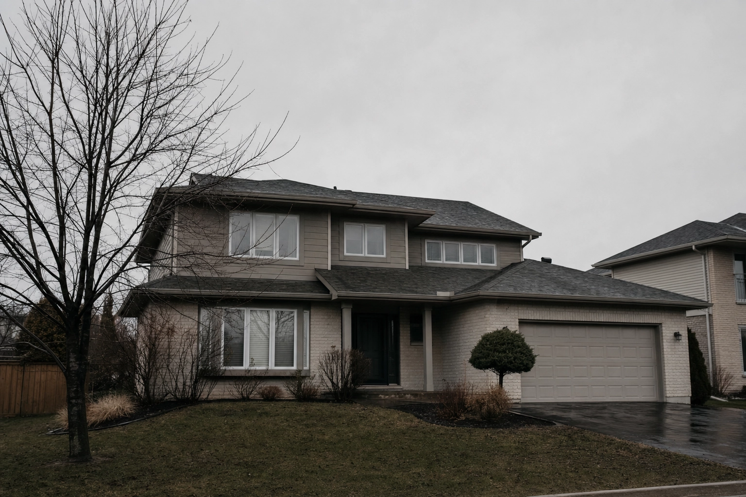 A family home under a flat grey overcast sky before sky replacement