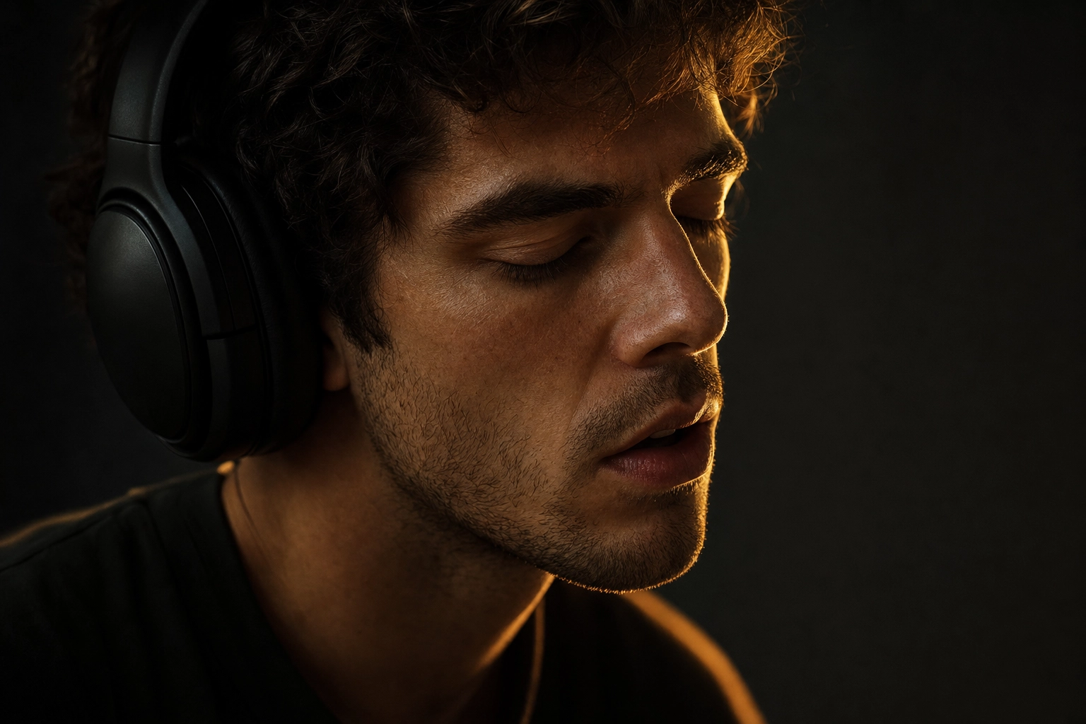 Learner in headphones listening and repeating English sounds with eyes closed, practising pronunciation by shadowing native speech