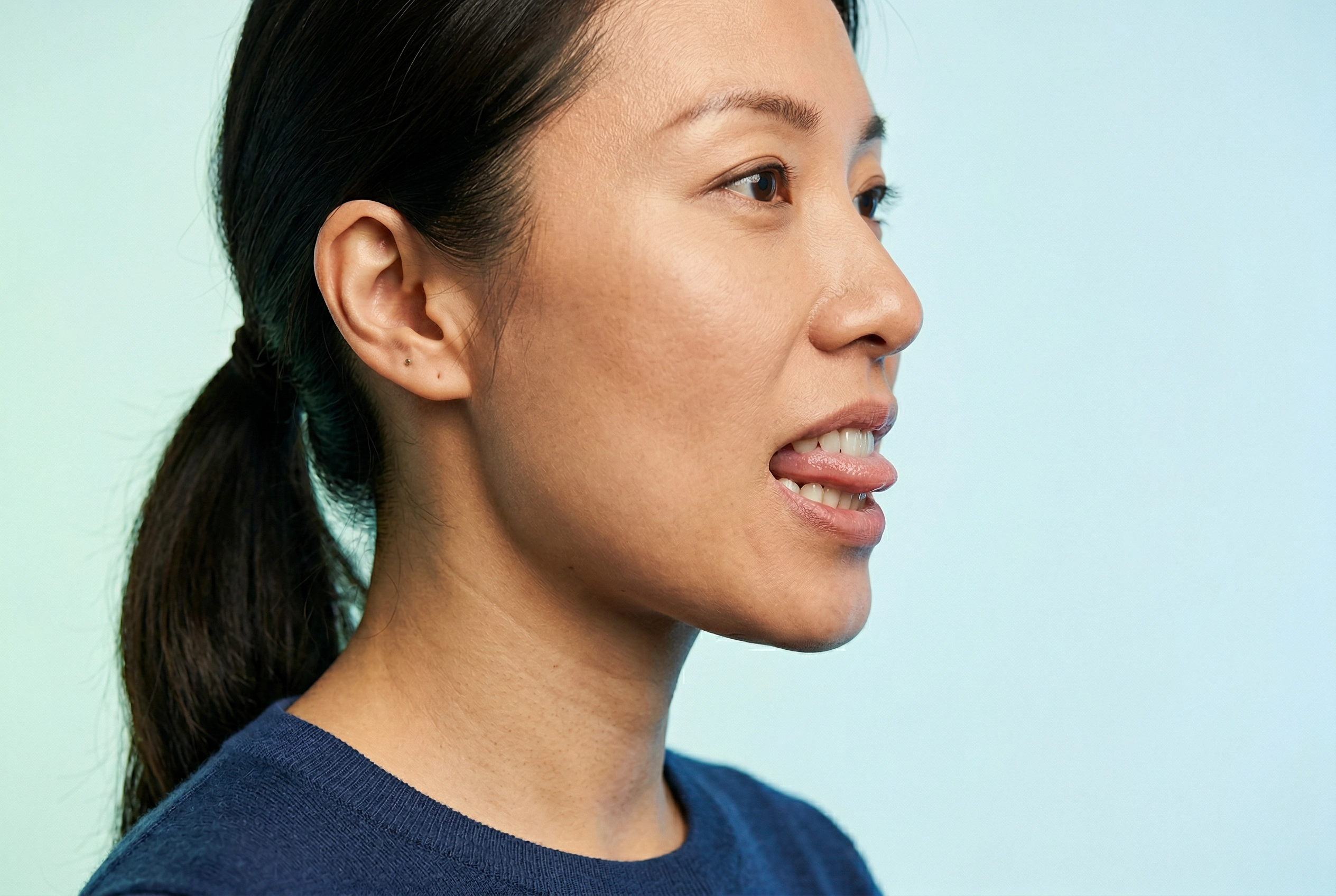 Demonstração em close-up do posicionamento da língua entre os dentes para o som TH, para aprendizes chineses de inglês