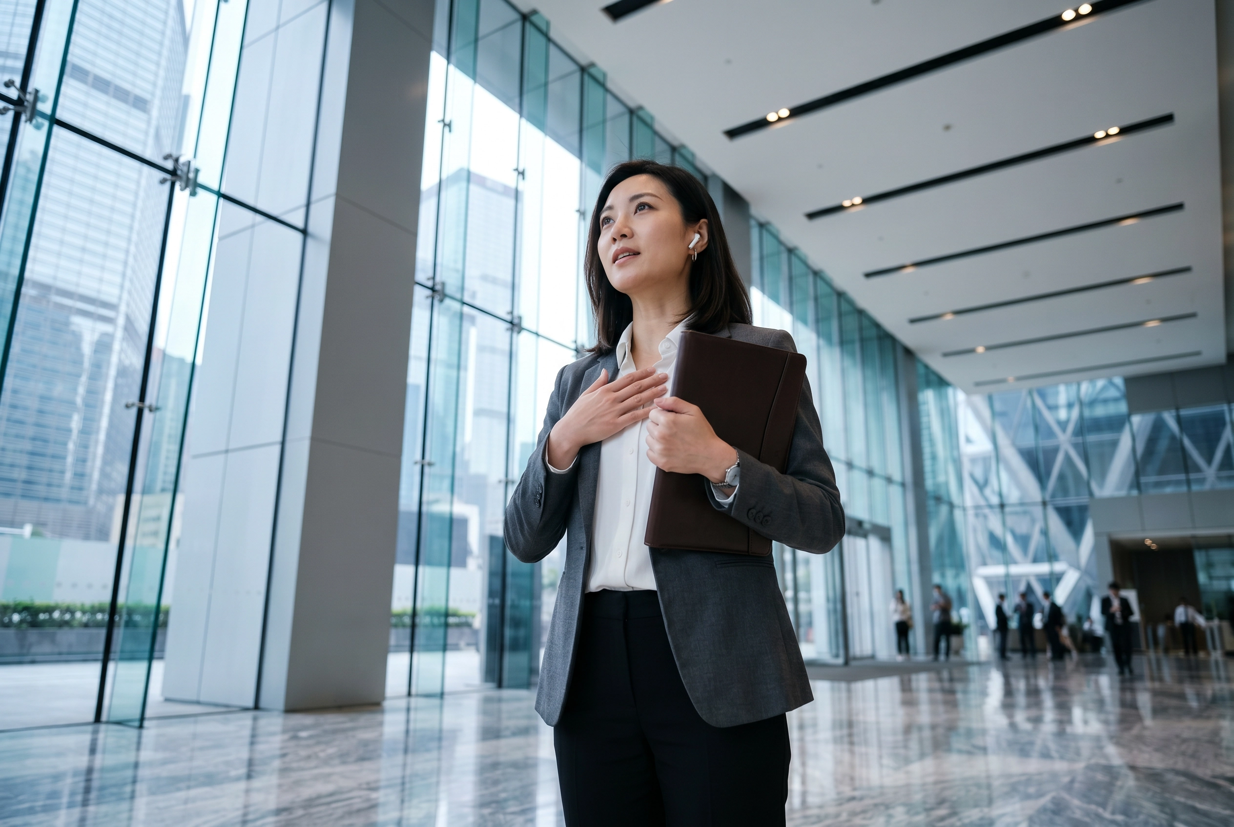 Wanita profesional berlatih wawancara kerja bahasa Inggris dengan AI di lobi perkantoran modern